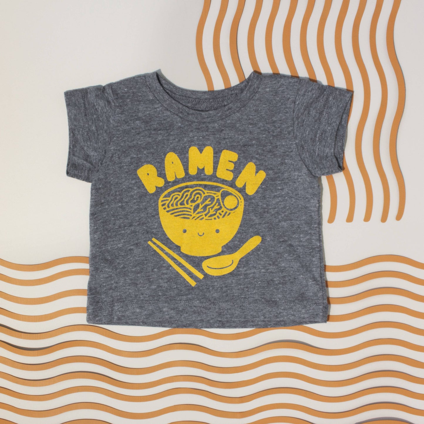 Dark gray toddler/kids tee with a kawaii bowl of ramen, printed in yellow ink, and text that reads "Ramen" across the chest