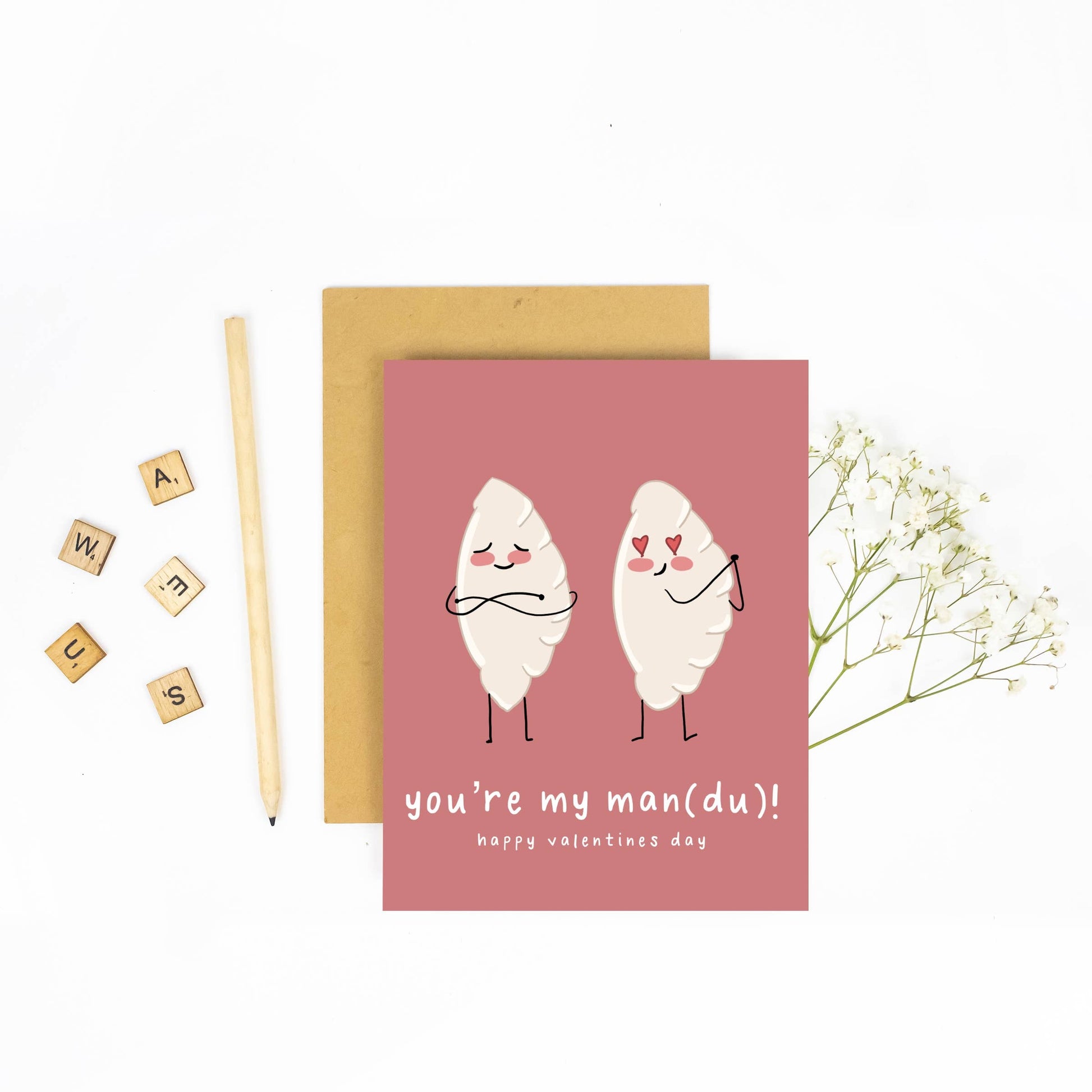 Pink greeting card with illustration of two mandu (korean dumplings) and text "you're my man(du)! happy valentine's day"