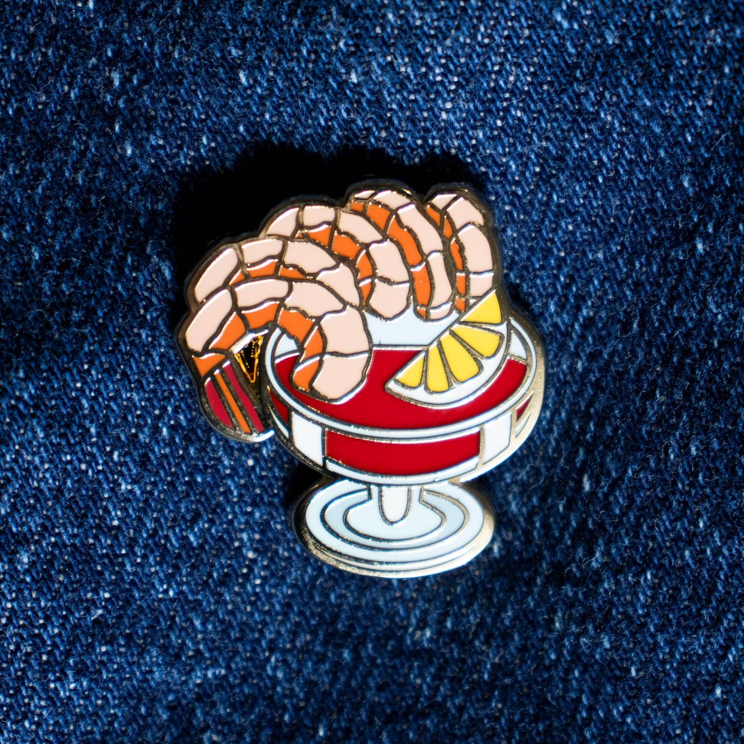 Shrimp cocktail lapel pin -- Five shrimp on a glass filled with cocktail sauce with a lemon wedge inside 