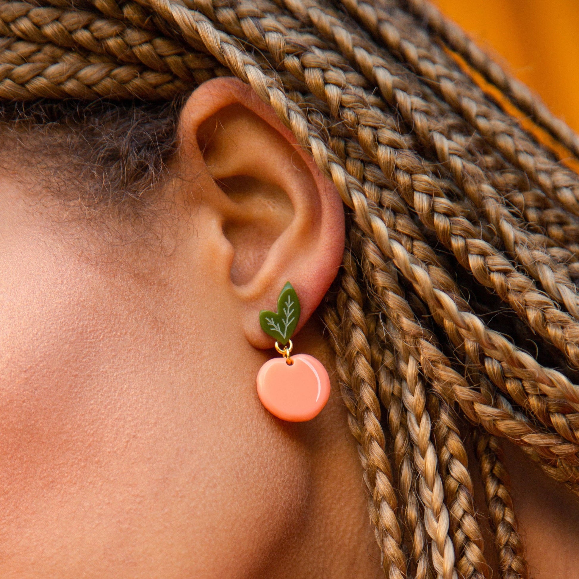 peach earrings worn on model 