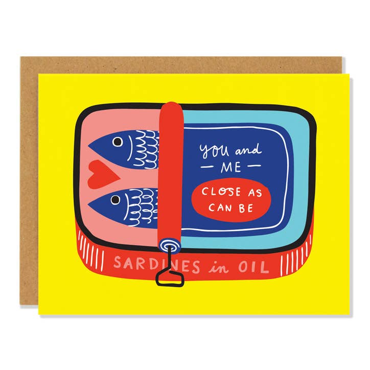 Yellow greeting card with a colorful illustration of a rectangular sardine can. The can is red, pink, dark and light blue. Two sardines are laying next to each other inside, the top of the can says "you and me -- close as can be" On the side of the can it reads "sardines in oil" Comes with a brown (kraft) envelope 