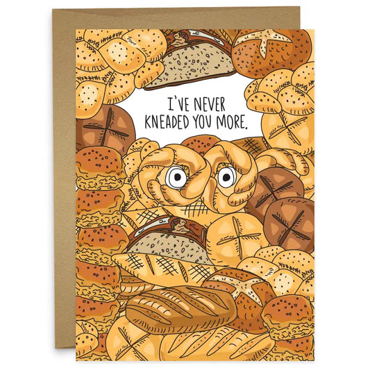 Bread greeting card that reads "I've Never Kneaded You More" and has different types of bread all over it .