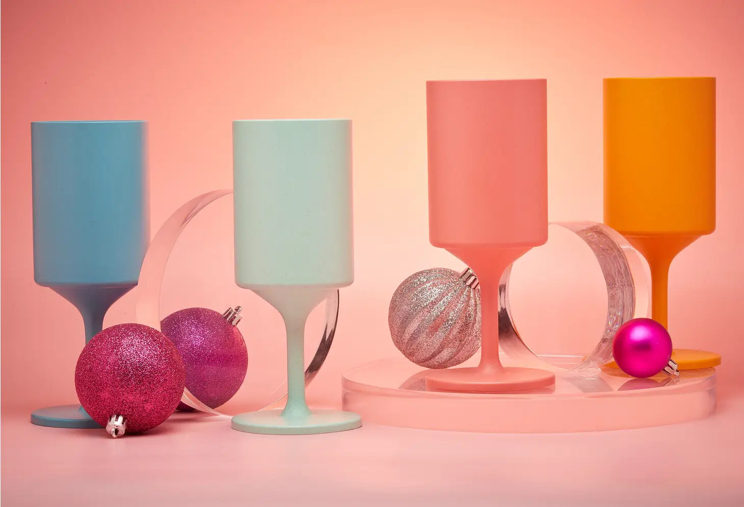 Fully compostable and reusable party cups or wine glasses in orange, coral, aqua and teal 