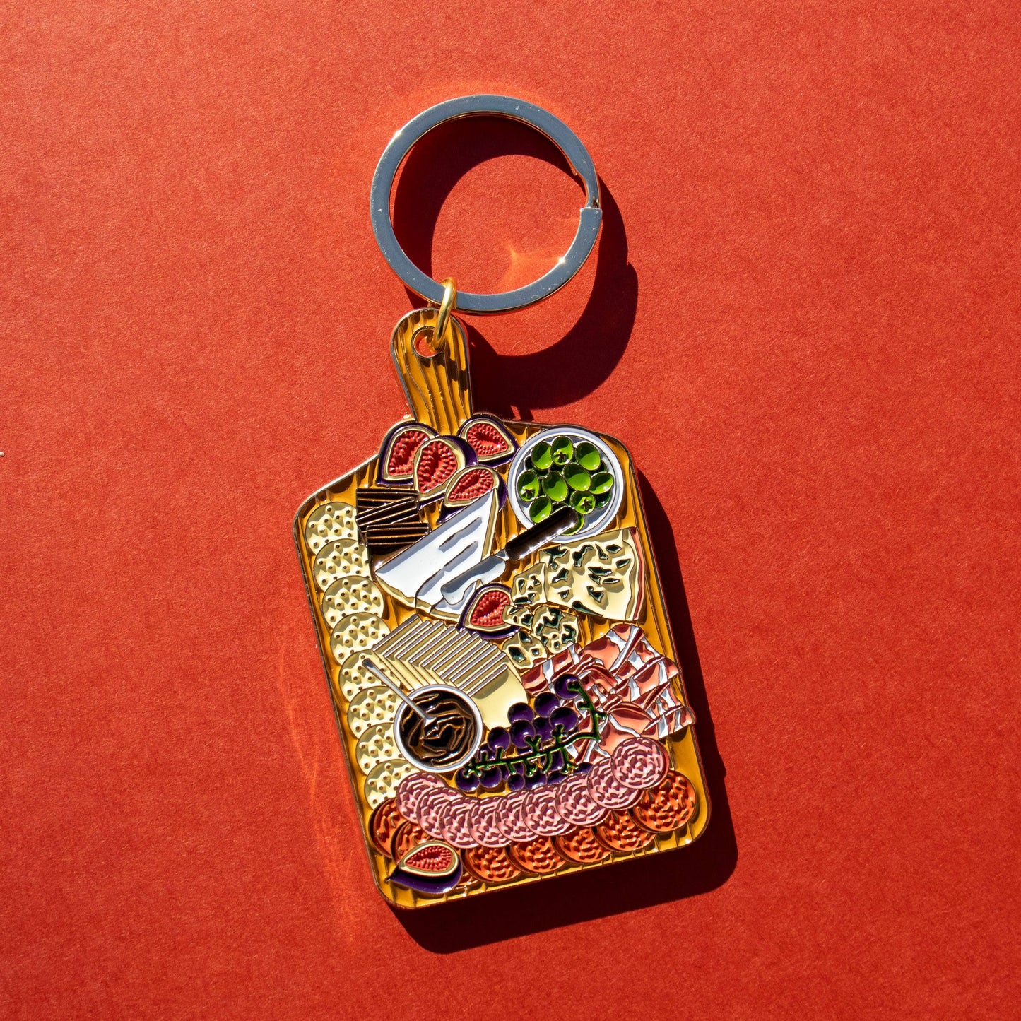 Charcuterie Board Keychain -- wooden board with crackers, various cured meats and cheeses, figs, olives and grapes
