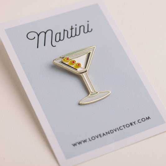 Martini cocktail enamel pin on light blue card backing 