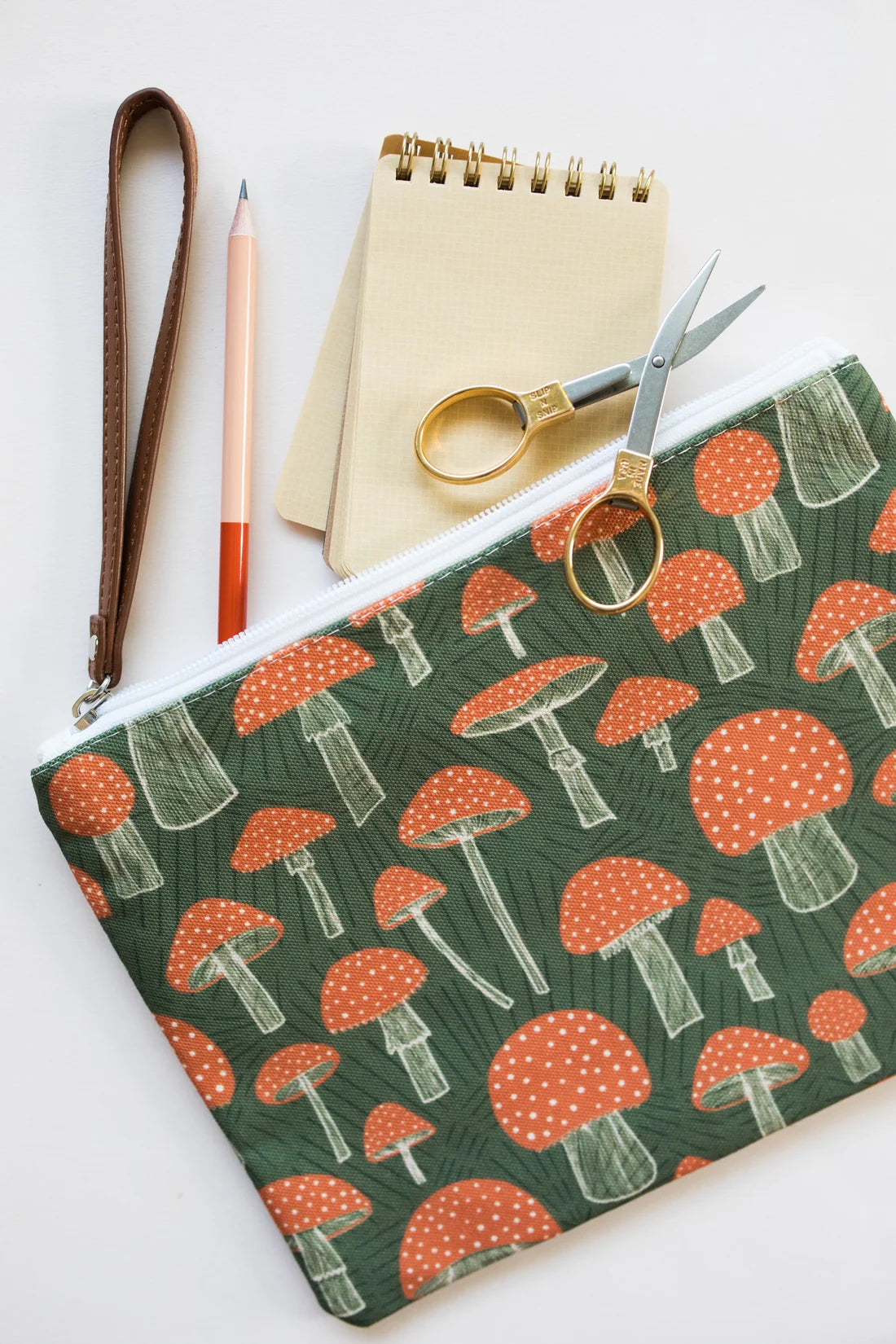Wristlet zippered pouch designed with mushrooms on it 