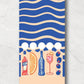 Spritz matchbook open to reaveal that the matches are in the shape of Campari, orange wedge, bubbles, spritz in a glass and olives on a pick.