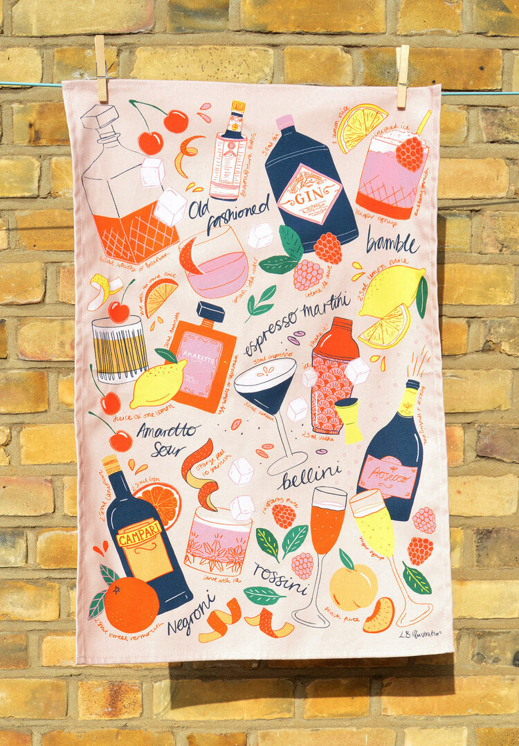 Cocktail Party tea towel or kitchen towel hung in front of a brick wall