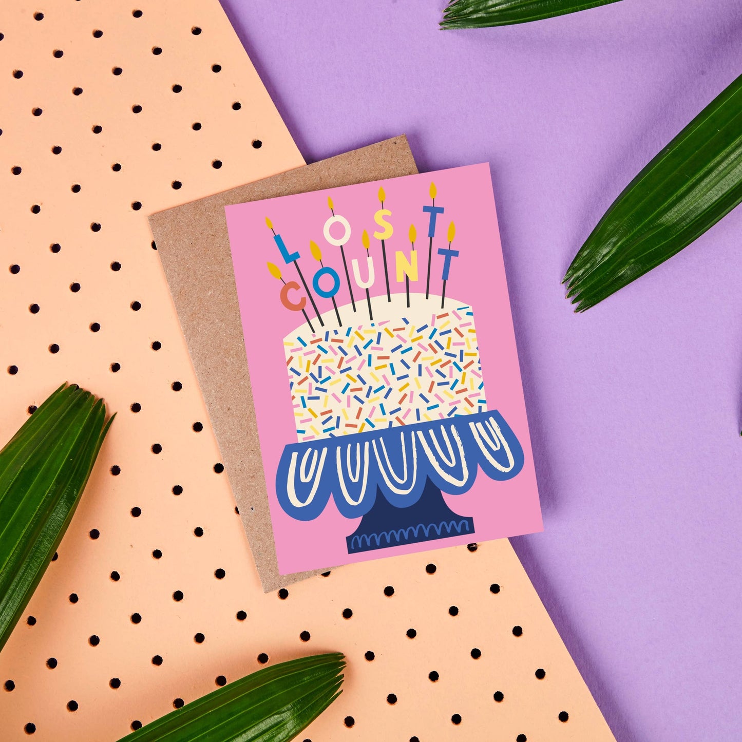 Birthday greeting card with a huge cake with candles that spell out LOST COUNT