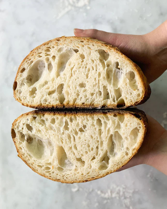 halved sourdough bread to show dough pockets 