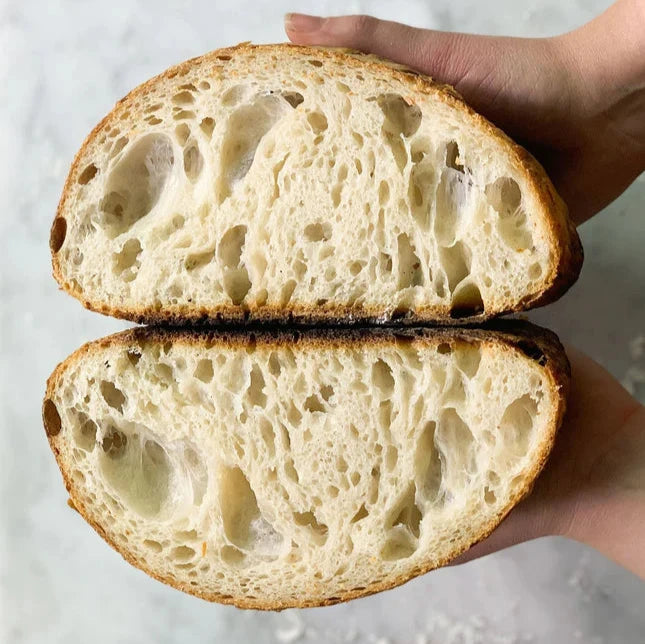 halved sourdough bread to show dough pockets 